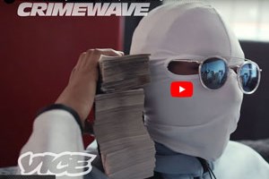 Paper representing money being held by a masked man