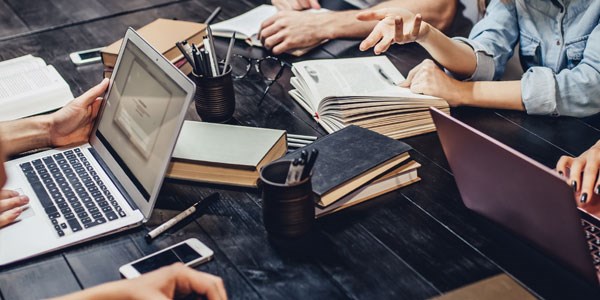 Laptops, books and pens on a table